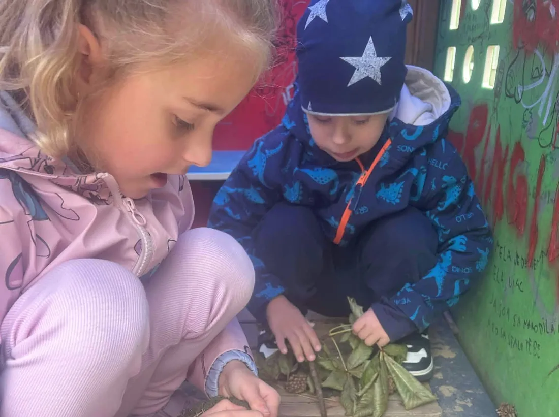 Staršie dievča a mladší chlapec spolu ukladajú listy